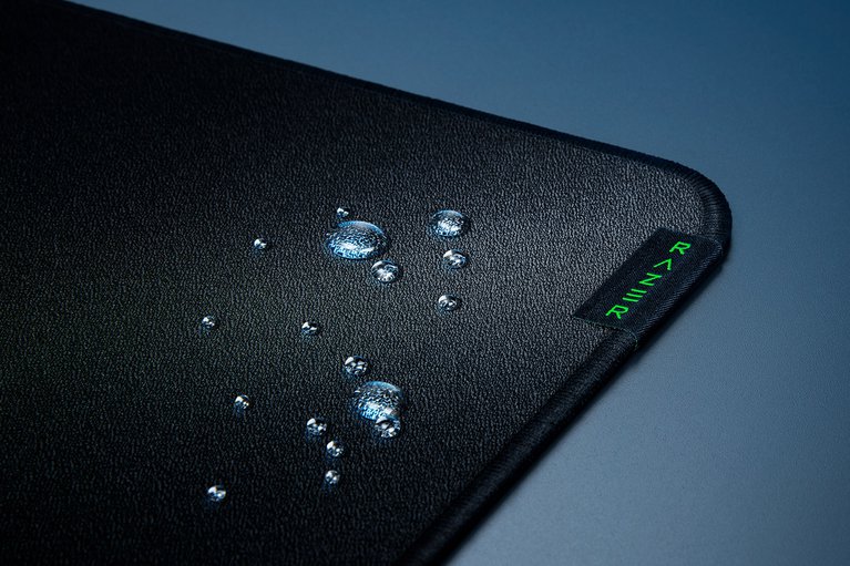 Razer Strider Razer Tag Closeup with Water Droplets Liquid Resistant - Silver Surface with Light